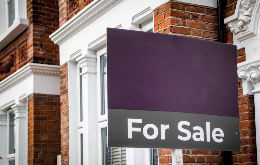 Purple for sale sign outside a home