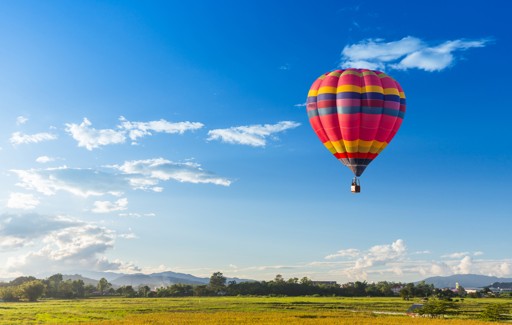 Colourful hot air balloon over a green field